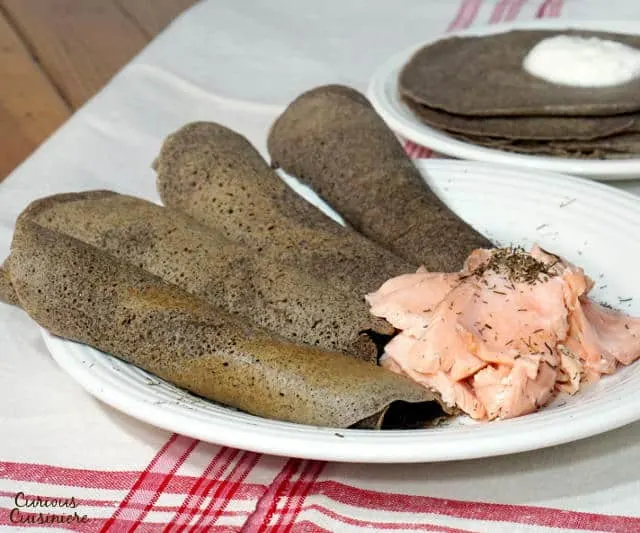 Thin Russian Pancakes, or Blini, remind us of French crepes, with a few differences. Try them with sweet or savory fillings. | www.CuriousCuisiniere.com