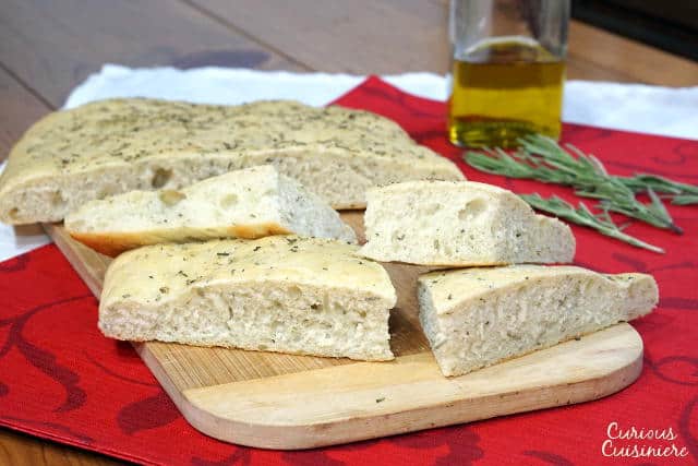 This soft, chewy Focaccia bread is flavored with rosemary and sea salt. It is perfect for serving as an appetizer or along side a pasta dinner! | www.CuriousCuisiniere.com 