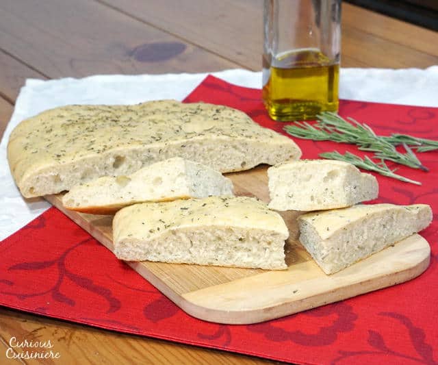This soft, chewy Focaccia bread is flavored with rosemary and sea salt. It is perfect for serving as an appetizer or along side a pasta dinner! | www.CuriousCuisiniere.com 