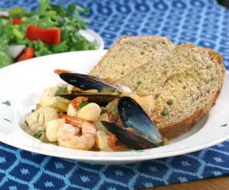 Cacciucco, a hearty Tuscan seafood stew, is served over toasted bread croutons for a fun and comforting meal. | www.CuriousCuisiniere.com