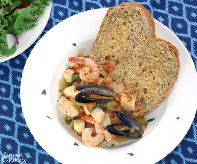 Cacciucco, a hearty Tuscan seafood stew, is served over toasted bread croutons for a fun and comforting meal. | www.CuriousCuisiniere.com