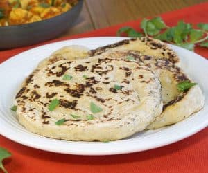 Our easy Naan recipe gives you perfectly textured, lightly charred, soft and chewy homemade Naan that is the perfect accompaniment to a saucy curry or lentil dal. | www.CuriousCuisiniere.com