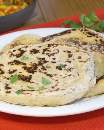 Our easy Naan recipe gives you perfectly textured, lightly charred, soft and chewy homemade Naan that is the perfect accompaniment to a saucy curry or lentil dal. | www.CuriousCuisiniere.com