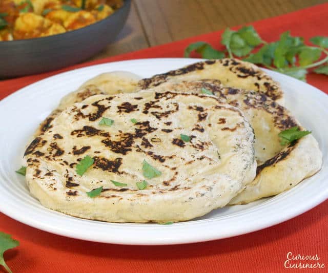 Our easy Naan recipe gives you perfectly textured, lightly charred, soft and chewy homemade Naan that is the perfect accompaniment to a saucy curry or lentil dal. | www.CuriousCuisiniere.com