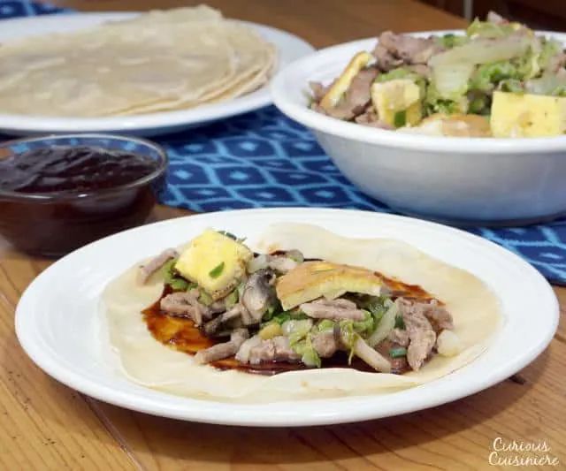 Moo Shu Pork is a traditional Chinese stir fry dish of pork, eggs, and mushrooms. This easy version comes together in a matter of minutes, making this recipe perfect for a weeknight dinner. | www.CuriousCuisiniere.com