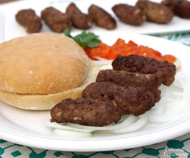 Cevapi are easy to make, grilled sausages from Southeastern Europe that burst with smoky flavor and are perfect for serving with flatbread and sliced onions. | www.CuriousCuisiniere.com