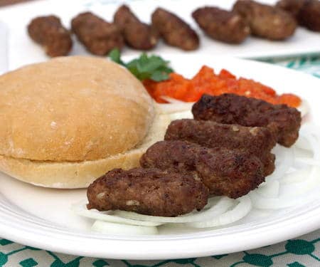 Cevapi are easy to make, grilled sausages from Southeastern Europe that burst with smoky flavor and are perfect for serving with flatbread and sliced onions. | www.CuriousCuisiniere.com