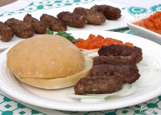 Cevapi are easy to make, grilled sausages from Southeastern Europe that burst with smoky flavor and are perfect for serving with flatbread and sliced onions. | www.CuriousCuisiniere.com