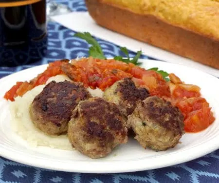 Frikkadel are a lightly spiced South African meatball that are often served with a sweet and herby tomato sauce, making a wonderfully comforting dinner that pairs perfectly with a South African Cabernet Sauvignon. | www.CuriousCuisiniere.com