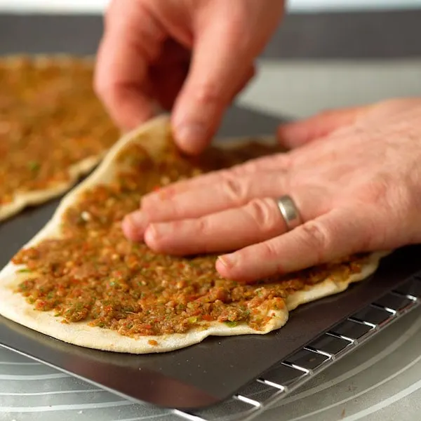 Stretching lahmacun, Turkish flatbread pizza, before baking