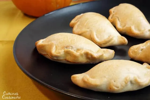 Lightly sweet and full of pumpkin pie flavor, these Baked Pumpkin Empanadas are a fun treat for any pumpkin lover! | www.CuriousCuisiniere.com