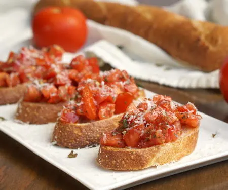 This recipe for a classic Tomato Basil Bruschetta features the perfect, bright and herby tomato topping served over crisp garlic toast. | www.CuriousCuisiniere.com