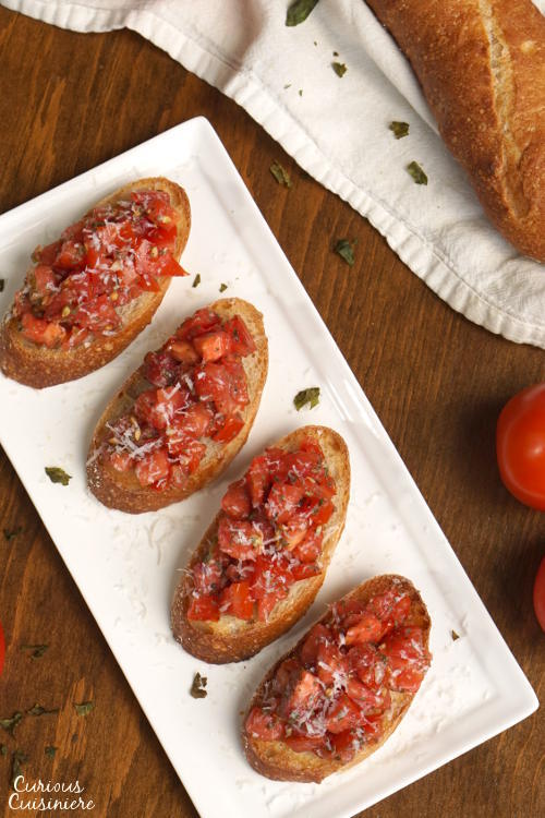This recipe for a classic Tomato Basil Bruschetta features the perfect, bright and herby tomato topping served over crisp garlic toast. | www.CuriousCuisiniere.com