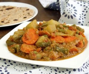 South Indian Vegetable Korma is a creamy coconut curry that is light on spice but big on flavor. This tasty dish is easy enough for a weeknight dinner! | www.CuriousCuisiniere.com