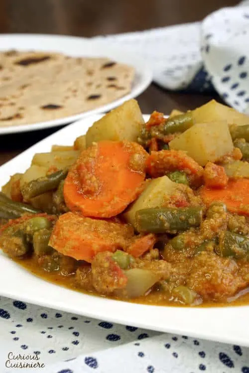 South Indian Vegetable Korma is a creamy coconut curry that is light on spice but big on flavor. This tasty dish is easy enough for a weeknight dinner! | www.CuriousCuisiniere.com