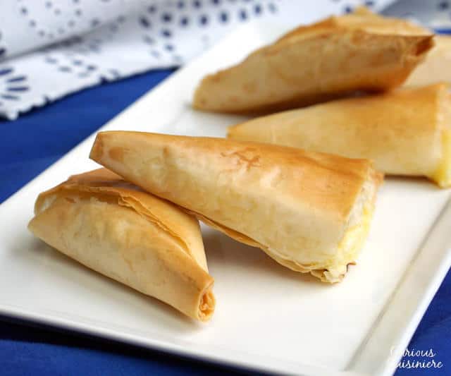 Light and flaky Greek pies filled with feta cheese, Tiropita make for a wonderful appetizer or snack that everyone is sure to enjoy! | www.CuriousCuisiniere.com