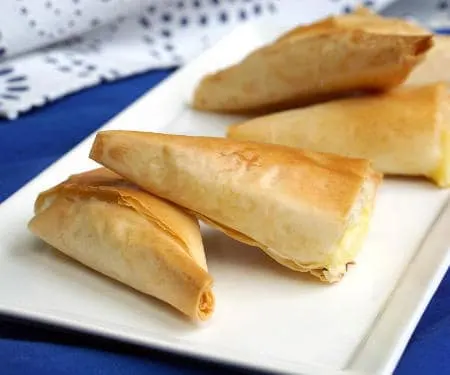 Light and flaky Greek pies pies filled with feta cheese, Tiropita make for a wonderful appetizer or snack that everyone is sure to enjoy! | www.CuriousCuisiniere.com