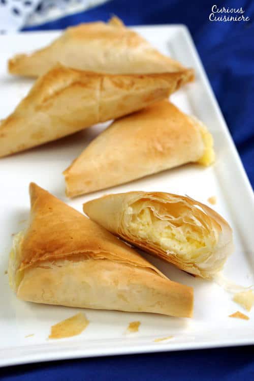 Light and flaky Greek pies filled with feta cheese, Tiropita make for a wonderful appetizer or snack that everyone is sure to enjoy! | www.CuriousCuisiniere.com
