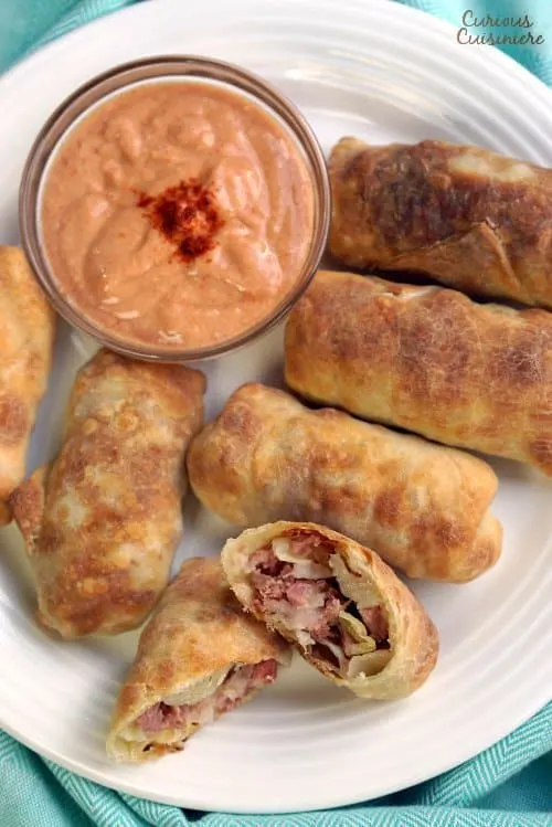All the flavor of a Reuben sandwich in a little hand-held appetizer, these Baked Reuben Egg Rolls are the perfect recipe for a St. Patrick's Day party or any party! | www.CuriousCuisiniere.com