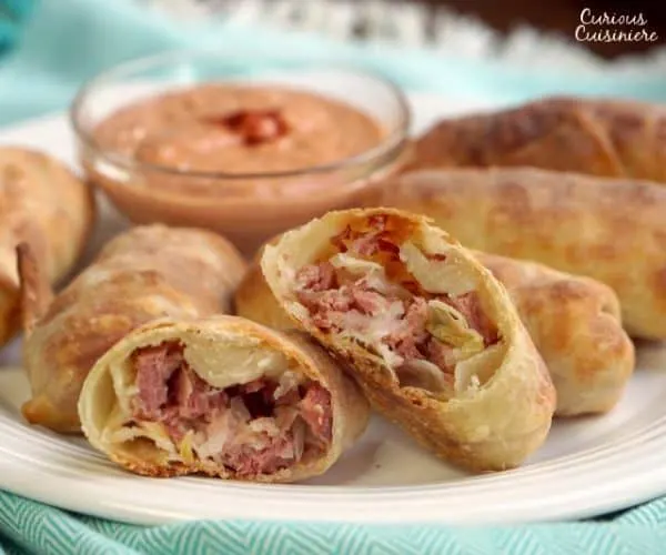 All the flavor of a Reuben sandwich in a little hand-held appetizer, these Baked Reuben Egg Rolls are the perfect recipe for a St. Patrick's Day party or any party! | www.CuriousCuisiniere.com
