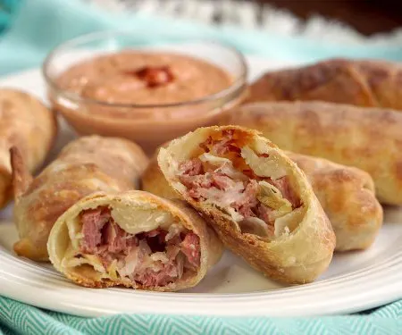 All the flavor of a Reuben sandwich in a little hand-held appetizer, these Baked Reuben Egg Rolls are the perfect recipe for a St. Patrick's Day party or any party! | www.CuriousCuisiniere.com