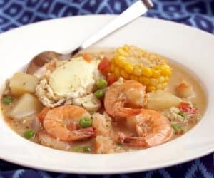 Chupe de Camarones is a unique Shrimp Chowder from Peru that combines a spicy broth with chunky vegetables, poached eggs, and lots of tasty shrimp. This is chowder like you have never seen it before. | www.CuriousCuisiniere.com