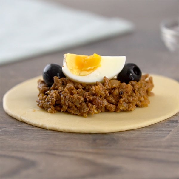 Filling empanadas de pino with meat, olives and egg