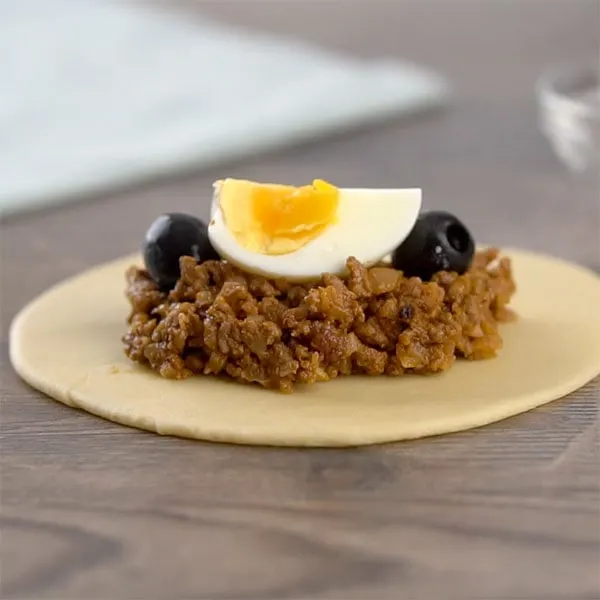 Filling empanadas de pino with meat, olives and egg