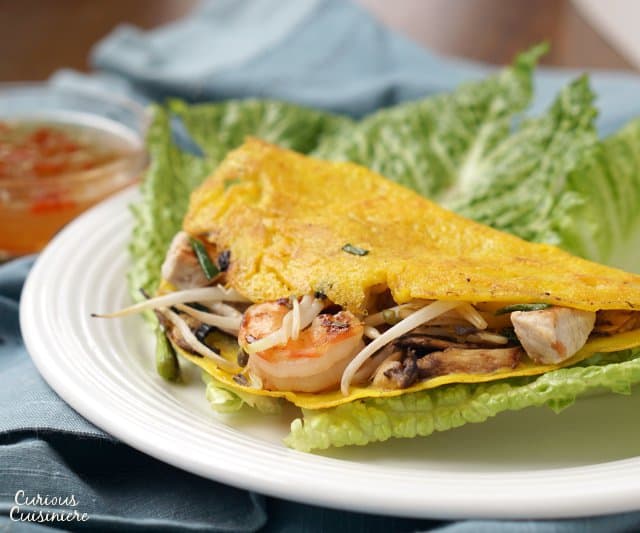 Bánh xèo, or Vietnamese Happy Pancakes, are crepe-like rice flour pancakes that bring a light batter and ample fillings together for one tasty, crispy breakfast or snack! | www.CuriousCuisiniere.com 