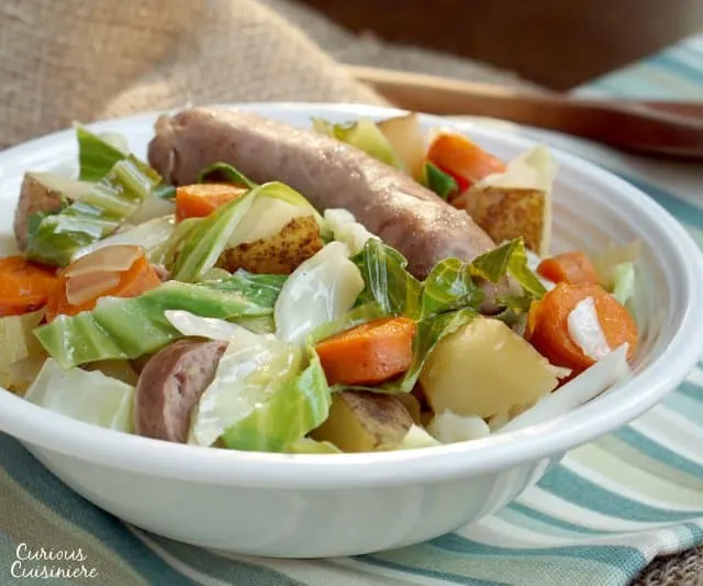 Bratwurst, potatoes, cabbage, and carrots mingle in this hearty Slow Cooker Oktoberfest Stew that gets an extra pump of flavor from a good dose of German beer. | www.CuriousCuisiniere.com