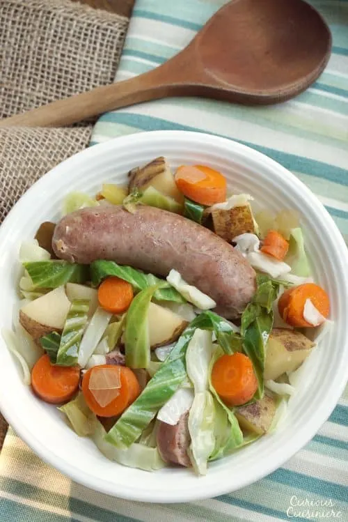 Bratwurst, potatoes, cabbage, and carrots mingle in this hearty Slow Cooker Oktoberfest Stew that gets an extra pump of flavor from a good dose of German beer. | www.CuriousCuisiniere.com