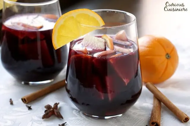 Warm spices and winter fruit make this Spiced Winter Sangria recipe a fun twist on your classic Spanish red sangria. | www.CuriousCuisiniere.com