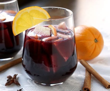 Warm spices and winter fruit make this Spiced Winter Sangria recipe a fun twist on your classic Spanish red sangria. | www.CuriousCuisiniere.com
