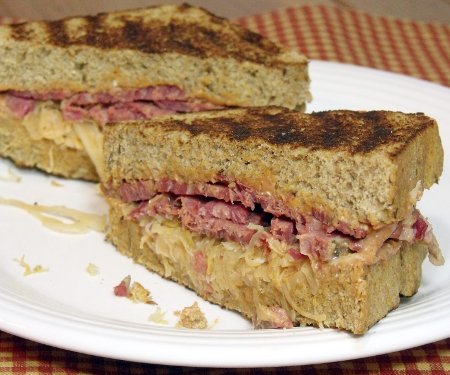 The classic grilled Reuben Sandwich, is crave-worthy comfort food. It's the perfect combination of crispy toast, flavorful corned beef, tangy sauerkraut, and creamy Russian dressing. Transform those corned beef leftovers! | www.CuriousCuisiniere.com