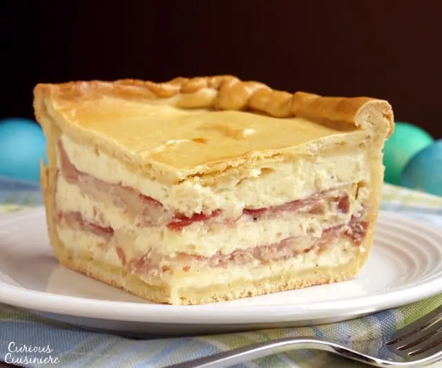 Pizza Gain (also known as Pizzagaina, Pizza Rustica, or Pizza Chiena) is an Italian Easter Pizza that is unlike any pizza you have ever tasted. Forget the tomato sauce, this filled pizza is more like a cheese and salami pie with a pizza crust. With beautiful layers, this impressive pie is the perfect dish for Easter brunch! | www.CuriousCuisiniere.com