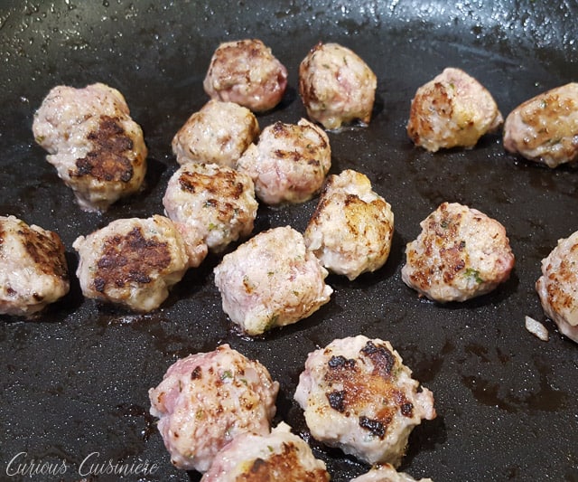 Spanish Meatballs, or Albondigas, are traditionally served at tapas bars in Spain. Whether you serve them for an appetizer, tapas party, or dinner main dish, these small meatballs in a flavorful tomato sauce are perfect for enjoying with a glass of red wine. | www.CuriousCuisiniere.com 
