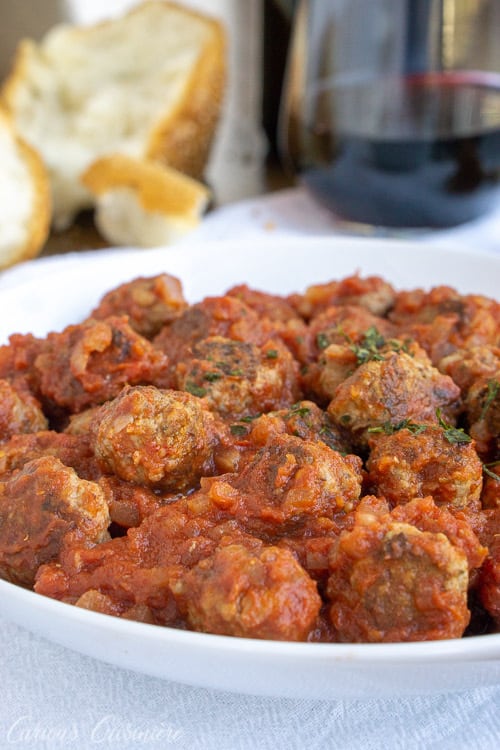 Spanish Meatballs, or Albondigas, are traditionally served at tapas bars in Spain. Whether you serve them for an appetizer, tapas party, or dinner main dish, these small meatballs in a flavorful tomato sauce are perfect for enjoying with a glass of red wine. | www.CuriousCuisiniere.com