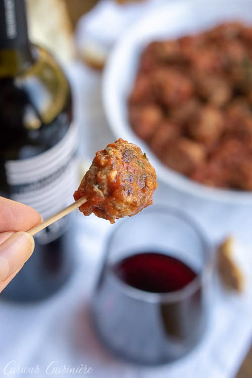Spanish Meatballs, or Albondigas, are traditionally served at tapas bars in Spain. Whether you serve them for an appetizer, tapas party, or dinner main dish, these small meatballs in a flavorful tomato sauce are perfect for enjoying with a glass of red wine. | www.CuriousCuisiniere.com