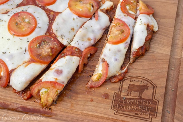 If you love steak and pizza, why not combine the two? Matambre a la Pizza is a fun Argentinian grilled steak appetizer that will be the star of your next summer cookout. Whether you serve it as an appetizer or dinner, this flank steak pizza is a guaranteed winner! | www.CuriousCuisiniere.com