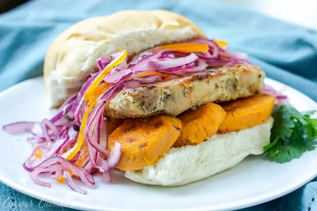 Pan Con Chicharron is a flavorful Peruvian sandwich made from the unique combination of slow braised pork and sweet potato topped with a crisp red onion relish. In Peru, it's traditionally eaten for breakfast, but we think it's the perfect meal for any time of day! | www.CuriousCuisiniere.com