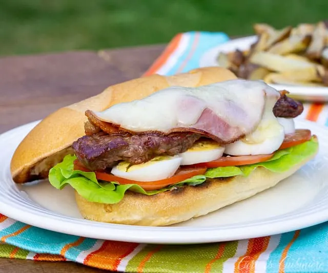 Chivito, the national dish of Uruguay, is a steak and egg sandwich unlike any other. This ultimate steak sandwich is perfect for a summer lunch or dinner! | www.CuriousCuisiniere.com