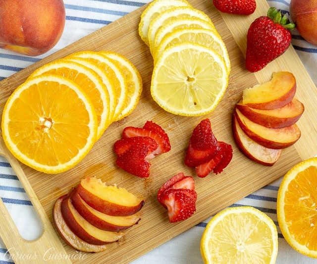 This Strawberry Peach Sangria is a fun twist on Spanish White Sangria. Fresh fruit, a crisp white wine, and a splash of brandy make this a summer favorite! | www.CuriousCuisiniere.com