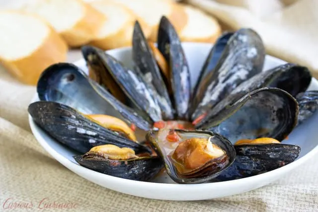 For an elegant summer appetizer, try these Galician Style Mussels in white wine and tomato sauce. These mussels are quick and easy to prepare. And, they are the perfect recipe to pair with a crisp Spanish white wine, like an Albariño. | www.CuriousCuisiniere.com 