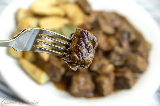 Carbonade Flamande is a Belgian beef stew with beer that is full of caramelized onions, bacon, and tender, slow cooked beef. Served with thick cut fries or boiled potatoes, this stew is the perfect recipe for winter comfort food.&nbsp;| www.CuriousCuisiniere.com