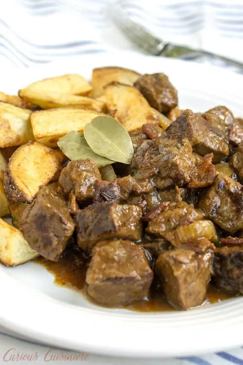 Carbonade Flamande is a Belgian beef stew with beer that is full of caramelized onions, bacon, and tender, slow cooked beef. Served with thick cut fries or boiled potatoes, this stew is the perfect recipe for winter comfort food.&nbsp;| www.CuriousCuisiniere.com