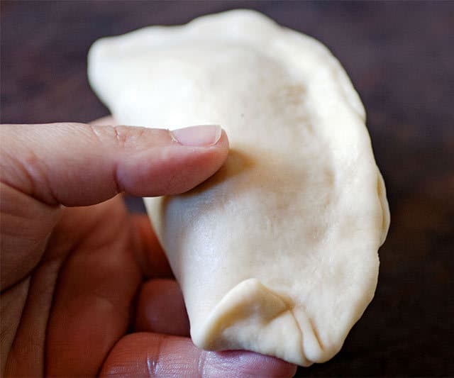 Starting the seal on chicken empanadas. | www.CuriousCuisiniere.com