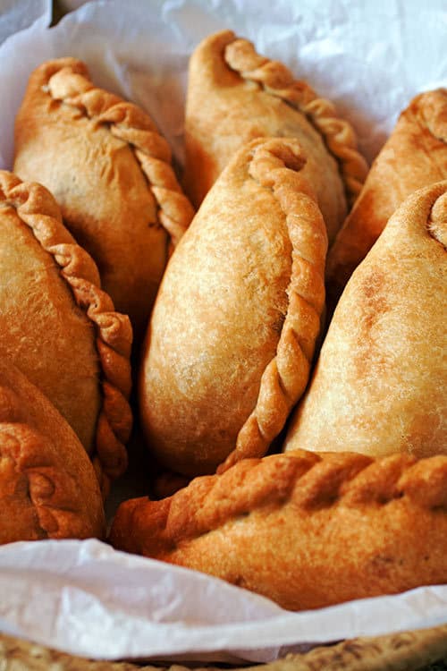 With a crispy-sweet crust and a juicy chicken filling, Empanadas de Pollo, Bolivian chicken empanadas, are a great recipe for your next get together. | www.CuriousCuisiniere.com