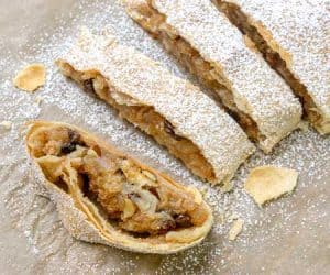 Wiener Apfelstrudel is a classic Viennese apple dessert that you probably know by the name of Apple Strudel. Flaky layers of strudel dough encase a bright fall apple filling that is studded with raisins and almonds. If you love apple pie, apple strudel is sure to be a winning recipe! | www.CuriousCuisiniere.com