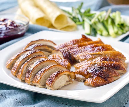 Beijing Roast Duck, also known as Peking Duck is a delicious way to prepare roast duck. It is traditionally served as Peking Duck pancakes, wrapped in Mandarin pancakes along with cucumber and plum or hoisin sauce. This recipe is easier than many traditional methods, but still yields a delicious duck, full of the classic flavors. | www.CuriousCuisiniere.com