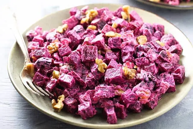 Russian Beet Salad with Prunes and Walnuts in a bowl with a fork/ | www.CuriousCuisiniere.com